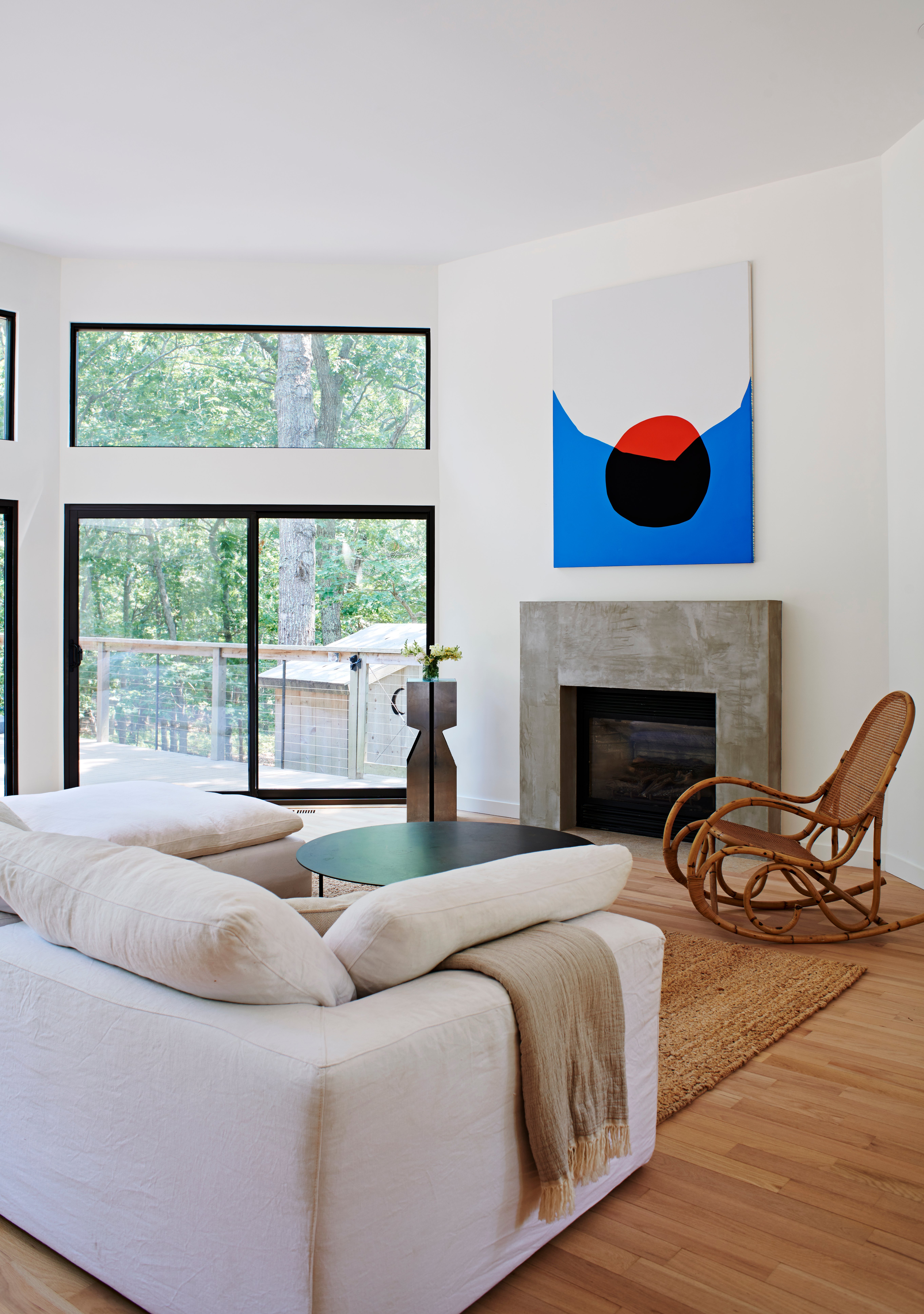 Modern living room with concrete fireplace and abstract art.