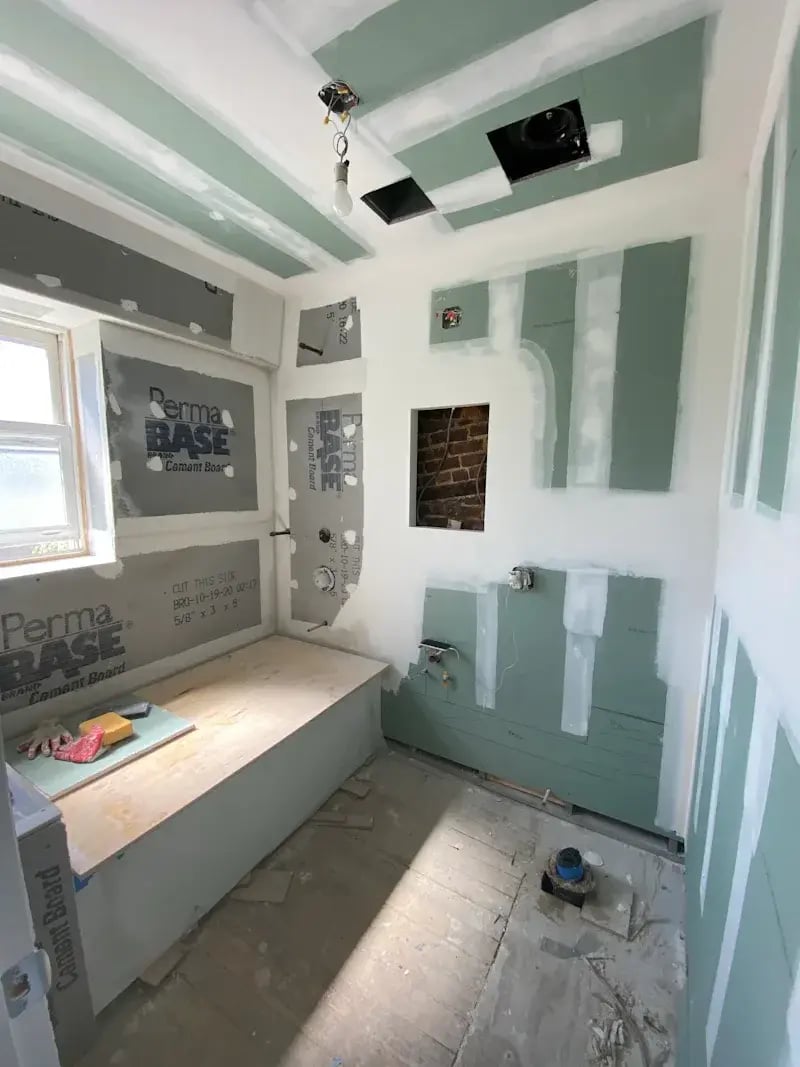 Unfinished bathroom with drywall and cement board.