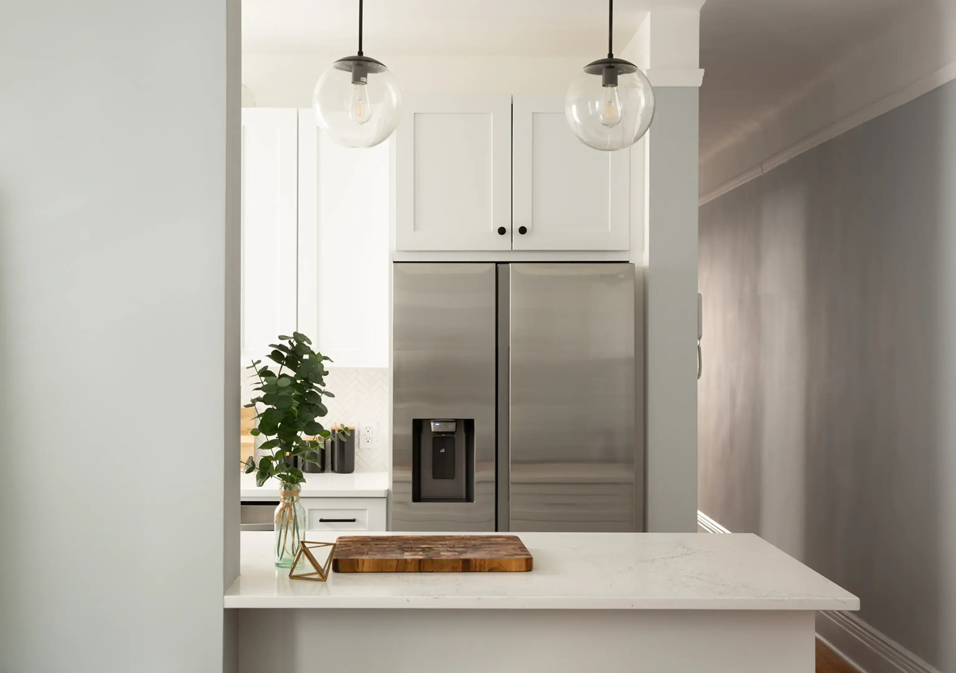 White kitchen with stainless steel refrigerator.