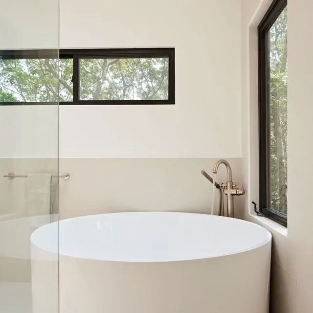 Modern bathroom with a round soaking tub and windows