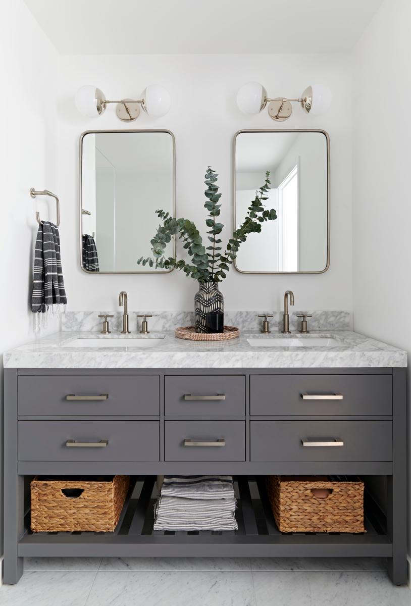 Bathroom vanity with marble top, grey cabinet, and silver fixtures