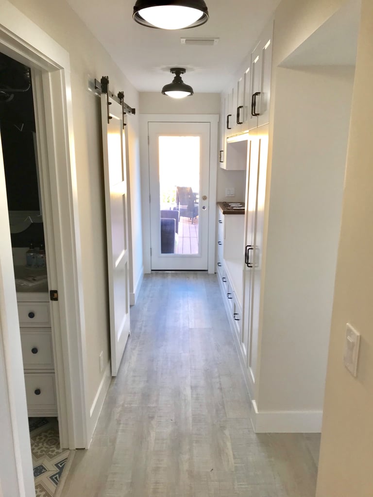 Hallway with continuous flooring in a remodeled beach house