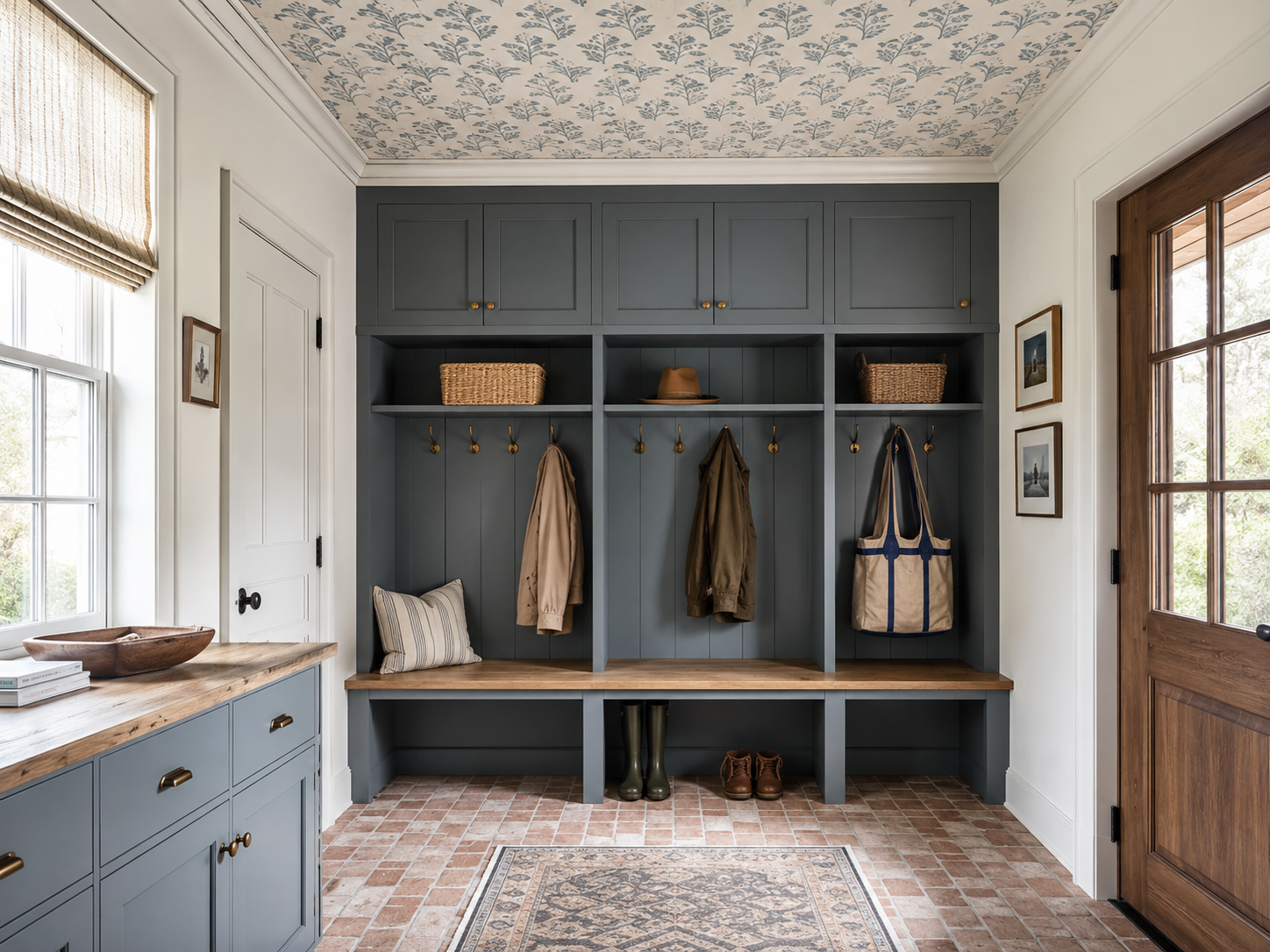 Mudroom with blue botanical wallpaper on the ceiling above dark gray built-in lockers