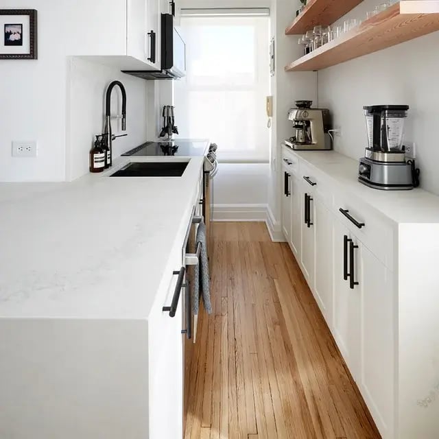 White galley kitchen with open shelving and wood floors