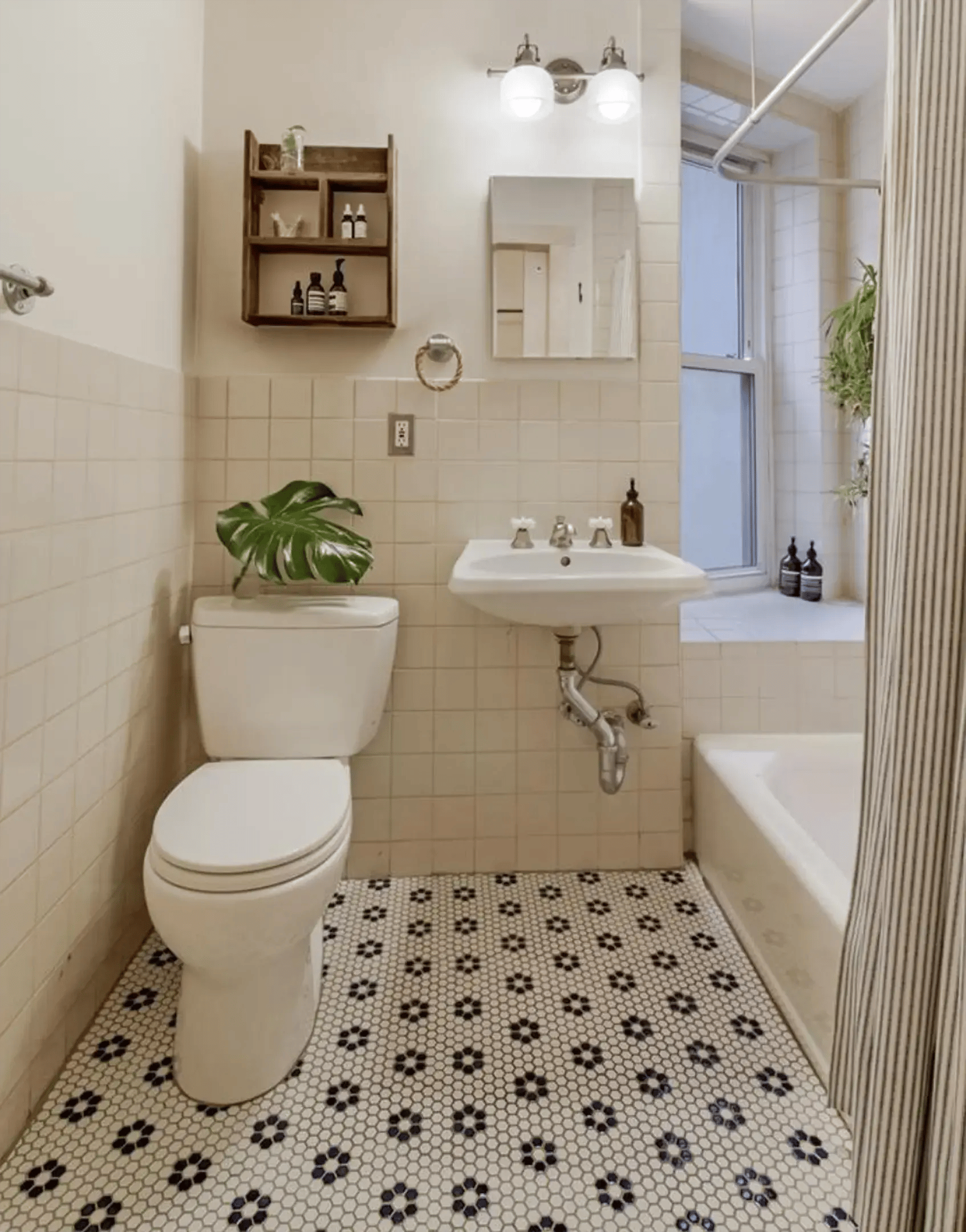 Beige tile bathroom with pedestal sink and patterned floor.