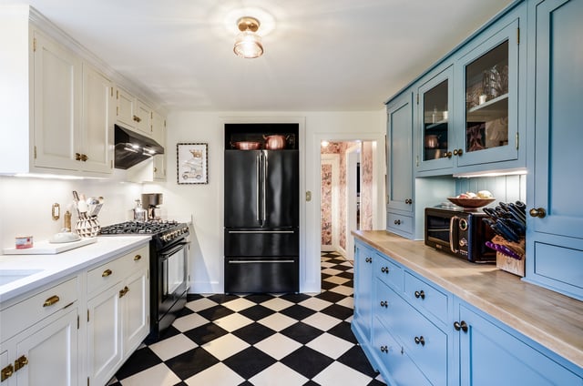 Charming kitchen with blue and white cabinets and checker floor.