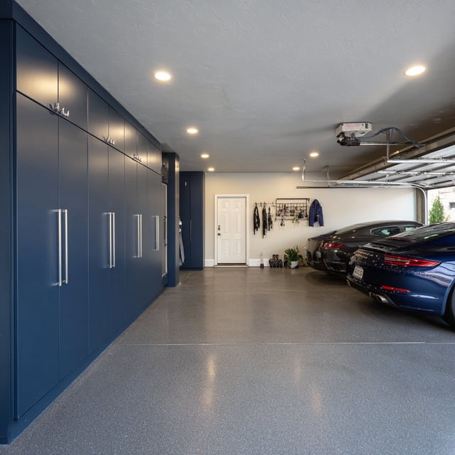  Modern garage with navy cabinets and epoxy resin flooring.
